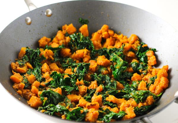 butternut squash and kale in a wok