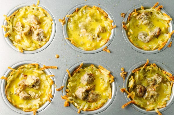 These Sausage Egg and Cheese Hash Brown Cups are so easy to make! Just layer everything in a muffin tin and bake, perfect for breakfast on the go! | Tastefulventure.com