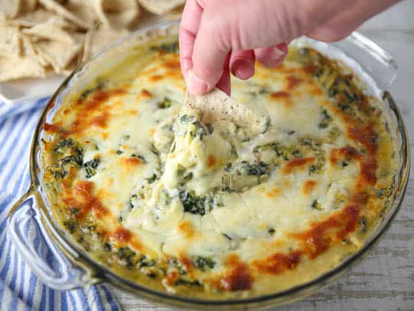 Dipping a chip in Hot Chipotle Spinach Artichoke Dip