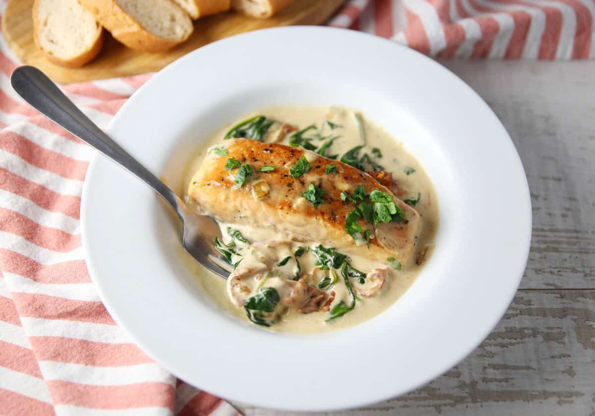 a fork dipping into creamy Tuscan Salmon